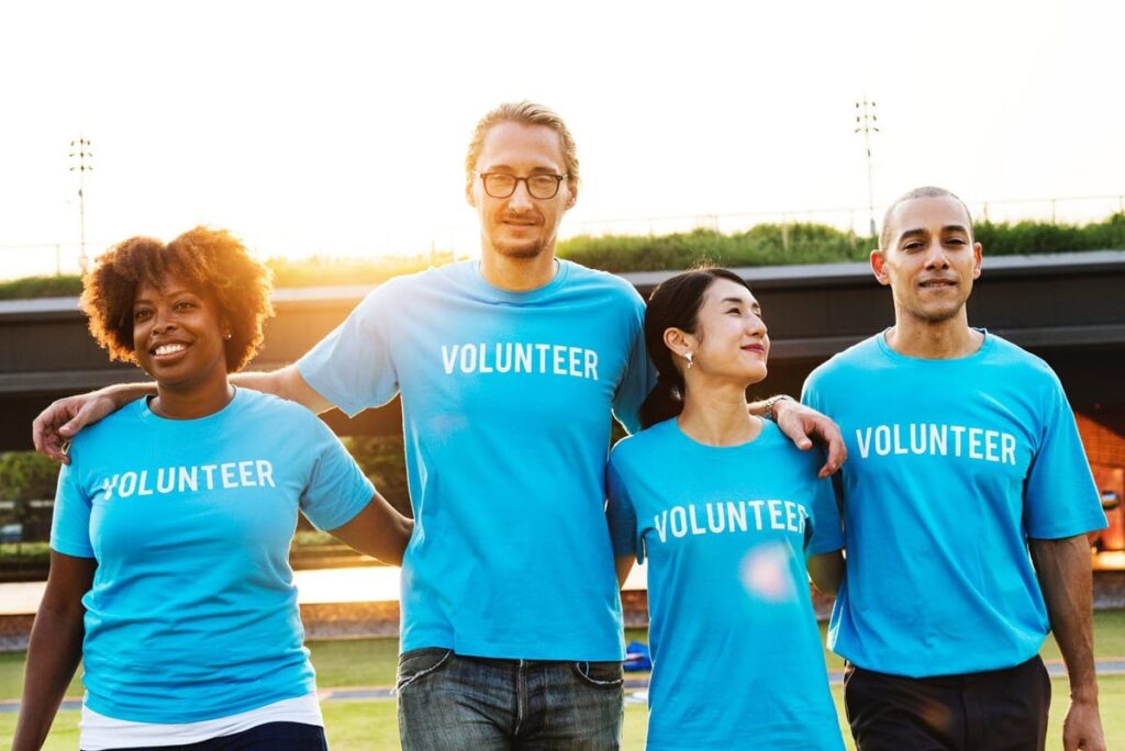 Two men and two women wearing vonluteer t-shirts